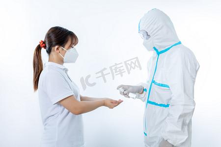 抗疫防疫医护人员棚拍穿防护服给人消毒摄影图配图