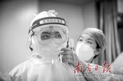 洪湖市人民医院的医护人员帮助广东医疗队队员整理防护用具.